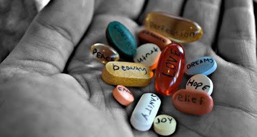 pillole colorare con scritte emozioni su mano grigia rappresenta psicologo come farmaco